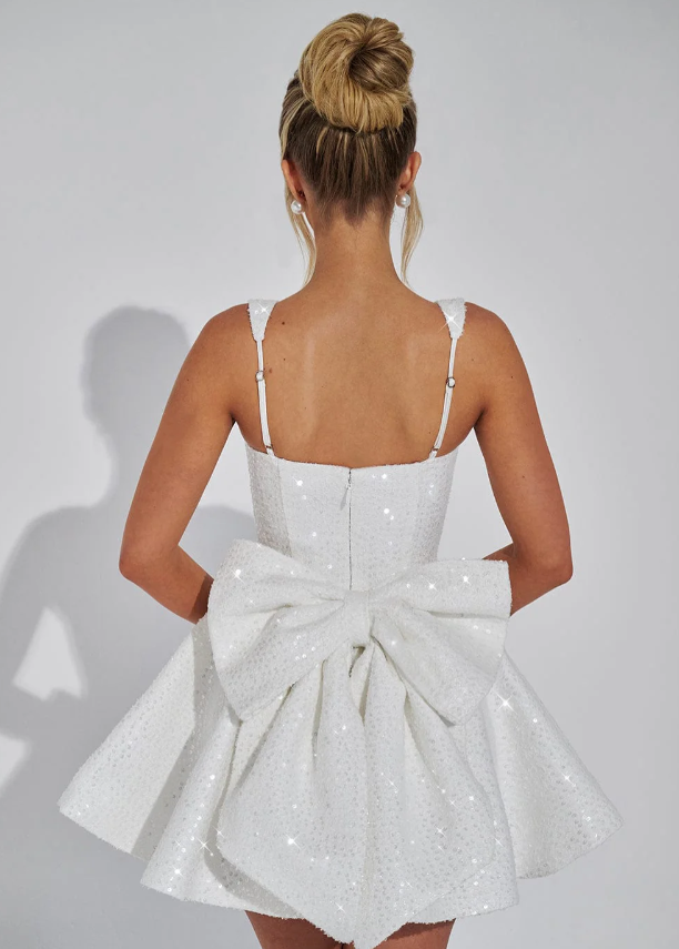 Back view of the white Giselle sequin mini dress featuring a large bow detail.