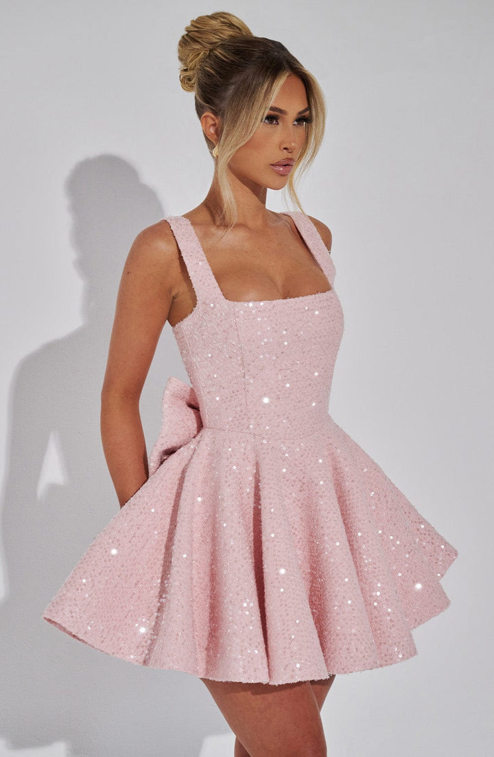 Pink sequin mini dress with a square neckline, flared skirt, and back bow detail.