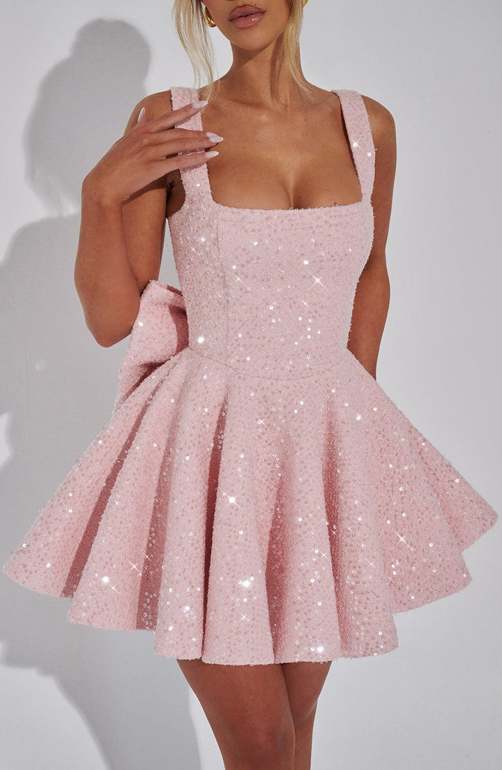 Pink sequin mini dress with a square neckline, flared skirt, and large back bow.