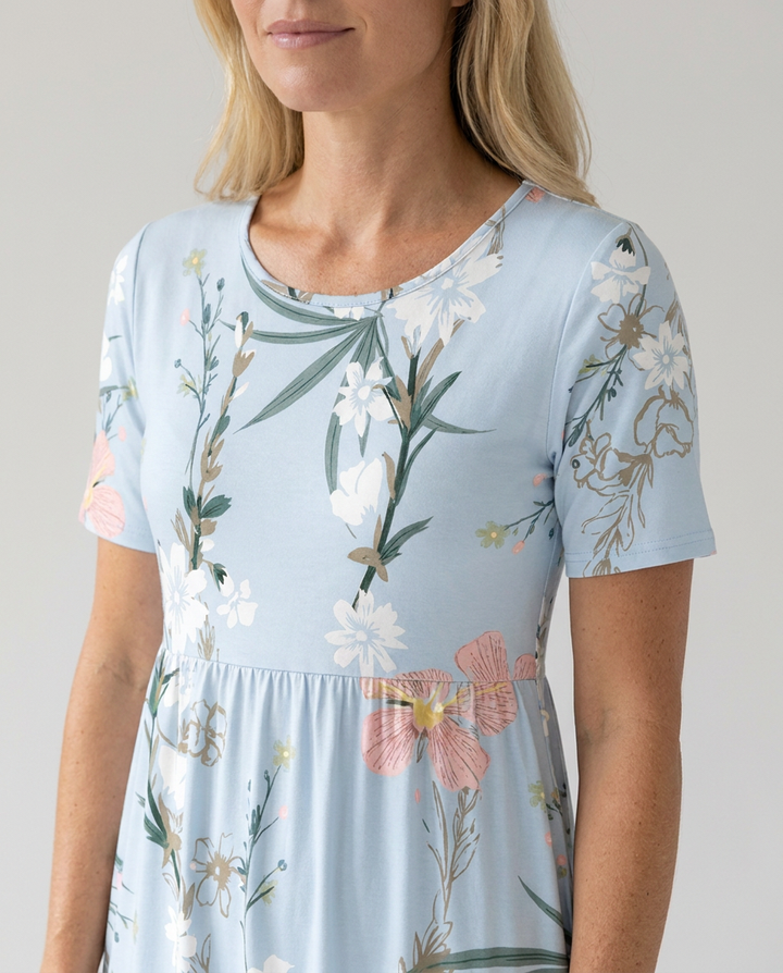 Women's Grace short sleeve midi dress in light blue with a vibrant floral print, round neckline, and gathered waist.