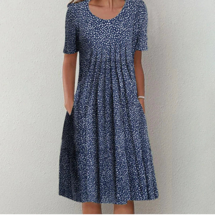 Women's polka dot midi dress with short sleeves and pockets.