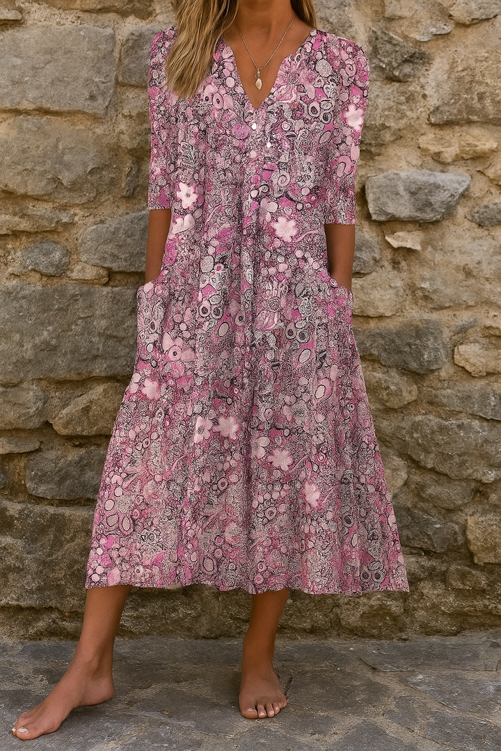 Pink women's printed midi dress with V-neck, 3/4 sleeves, and flowing skirt.