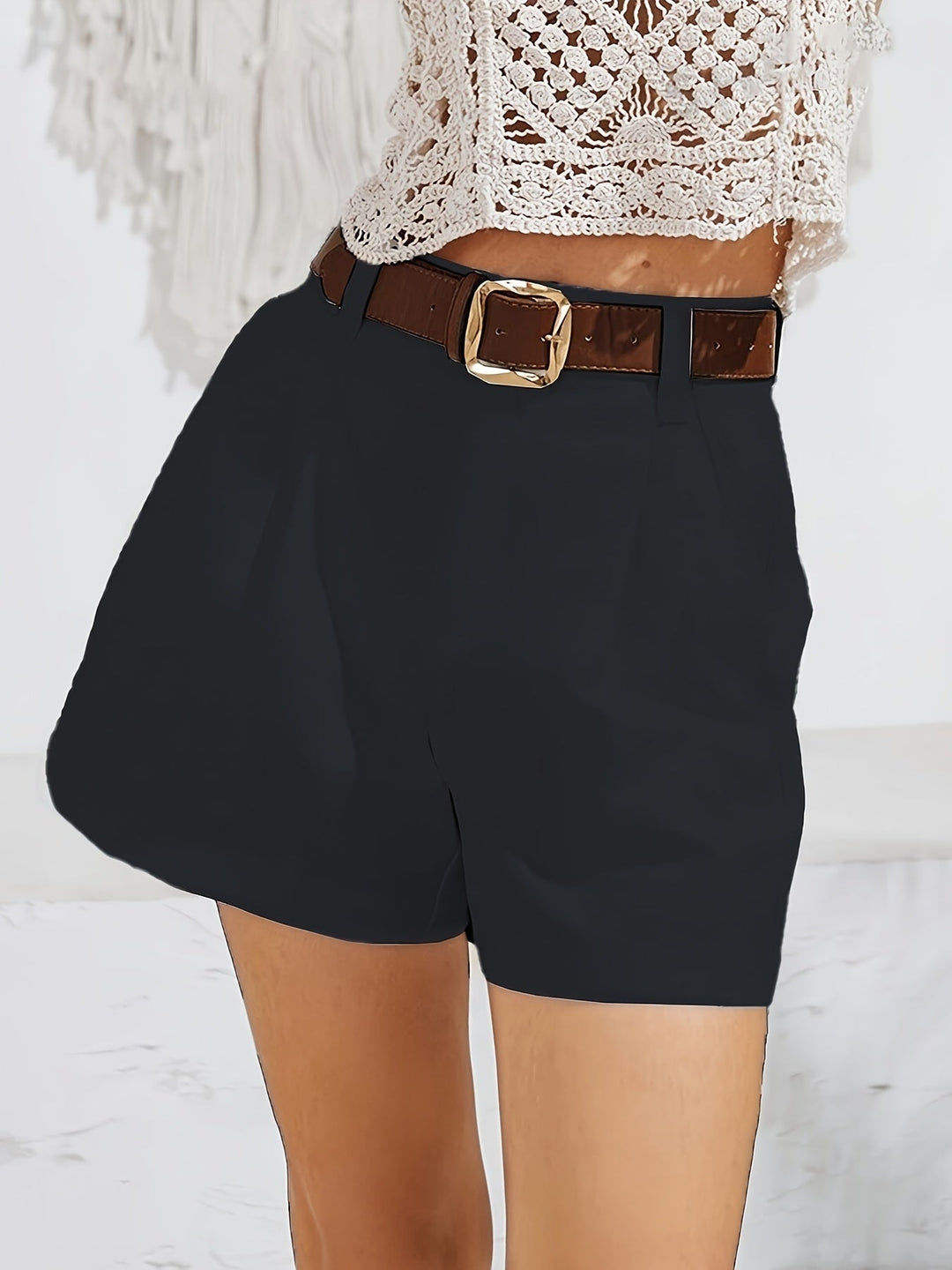 Harper high-waisted black shorts with a brown leather belt and gold buckle.