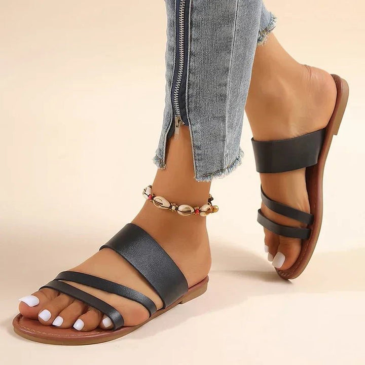 Tan leather women's cross strap flat sandals with a low heel, perfect for summer.