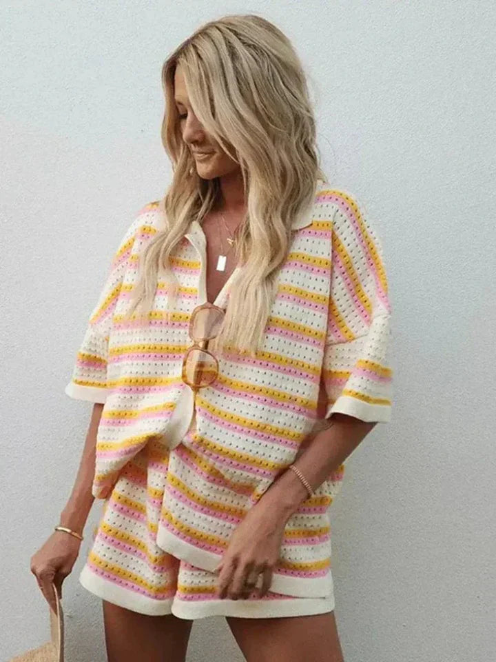 Blonde woman wearing a striped knit shorts set with a button-front top in pink, yellow, and white.