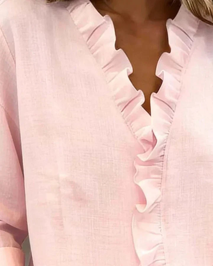 White women's V-neck ruffle blouse with long sleeves, featuring a relaxed fit and delicate fabric.