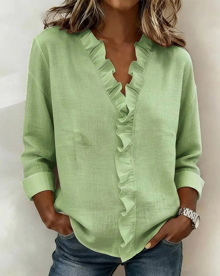 Green women's V-neck ruffle blouse with long sleeves, made from a lightweight fabric.