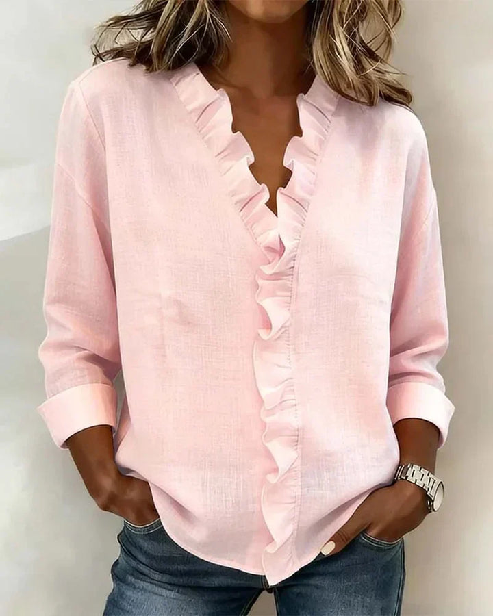 Pink V-neck ruffle blouse with long sleeves for women.