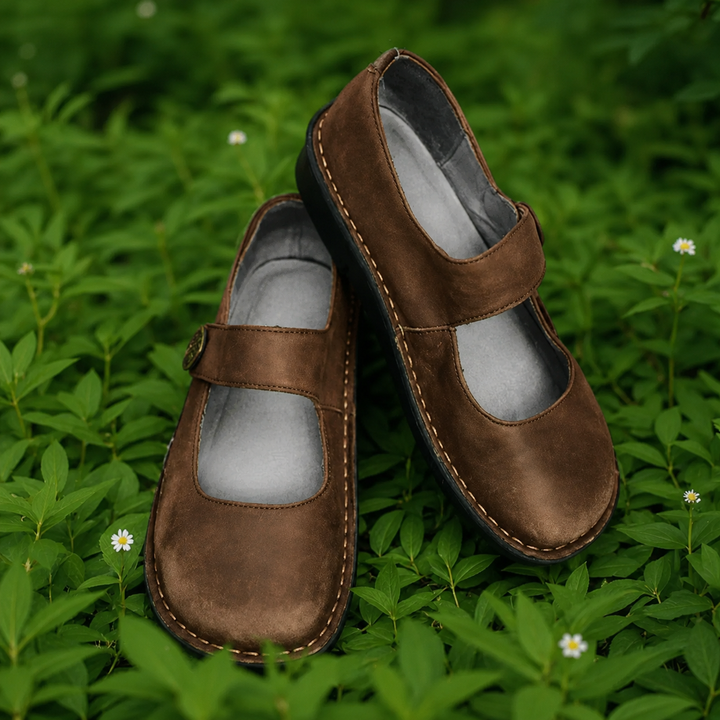 Isla brown leather Mary Jane shoes with cushioned insoles on green foliage.