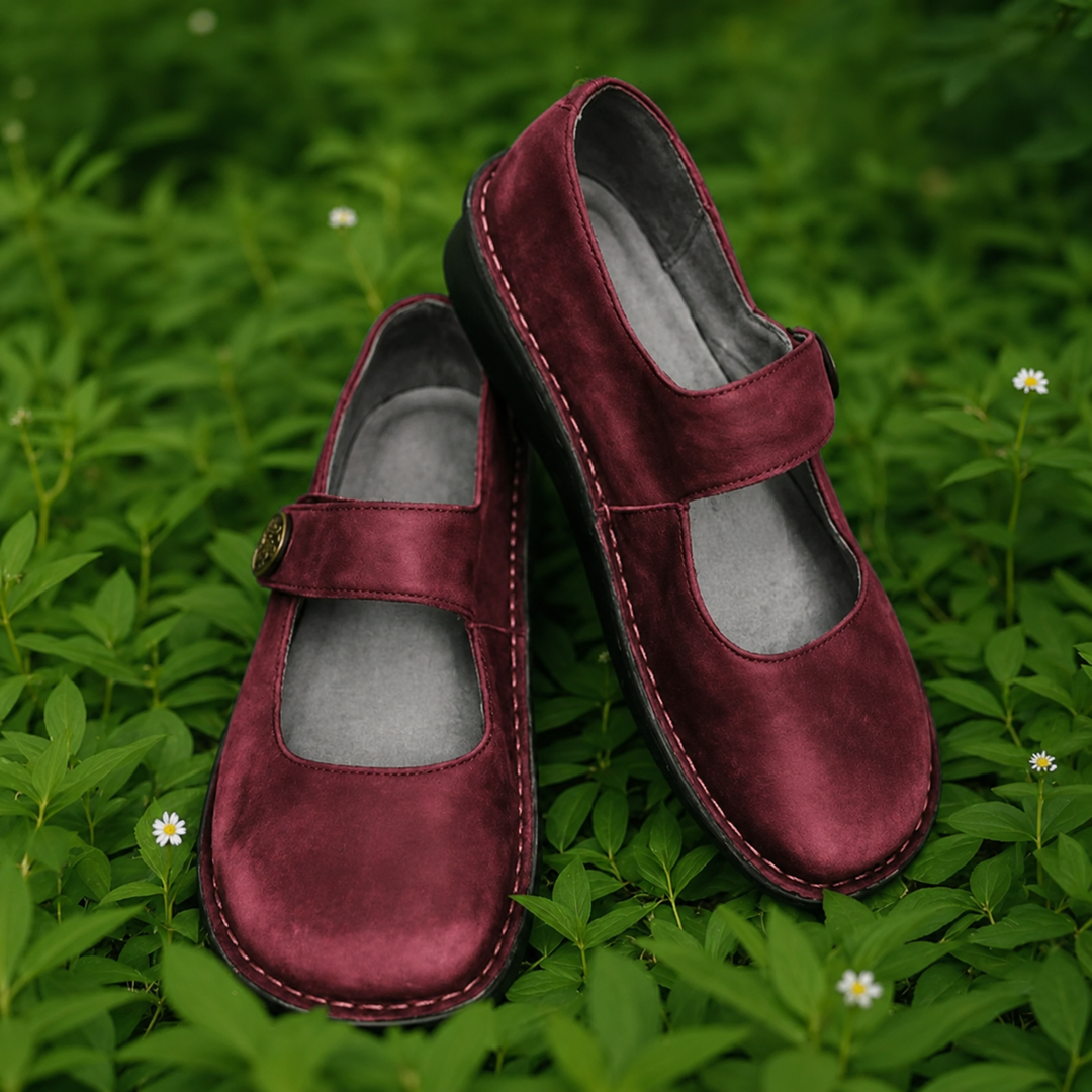 Isla burgundy suede Mary Jane shoes with cushioned insoles on green grass.