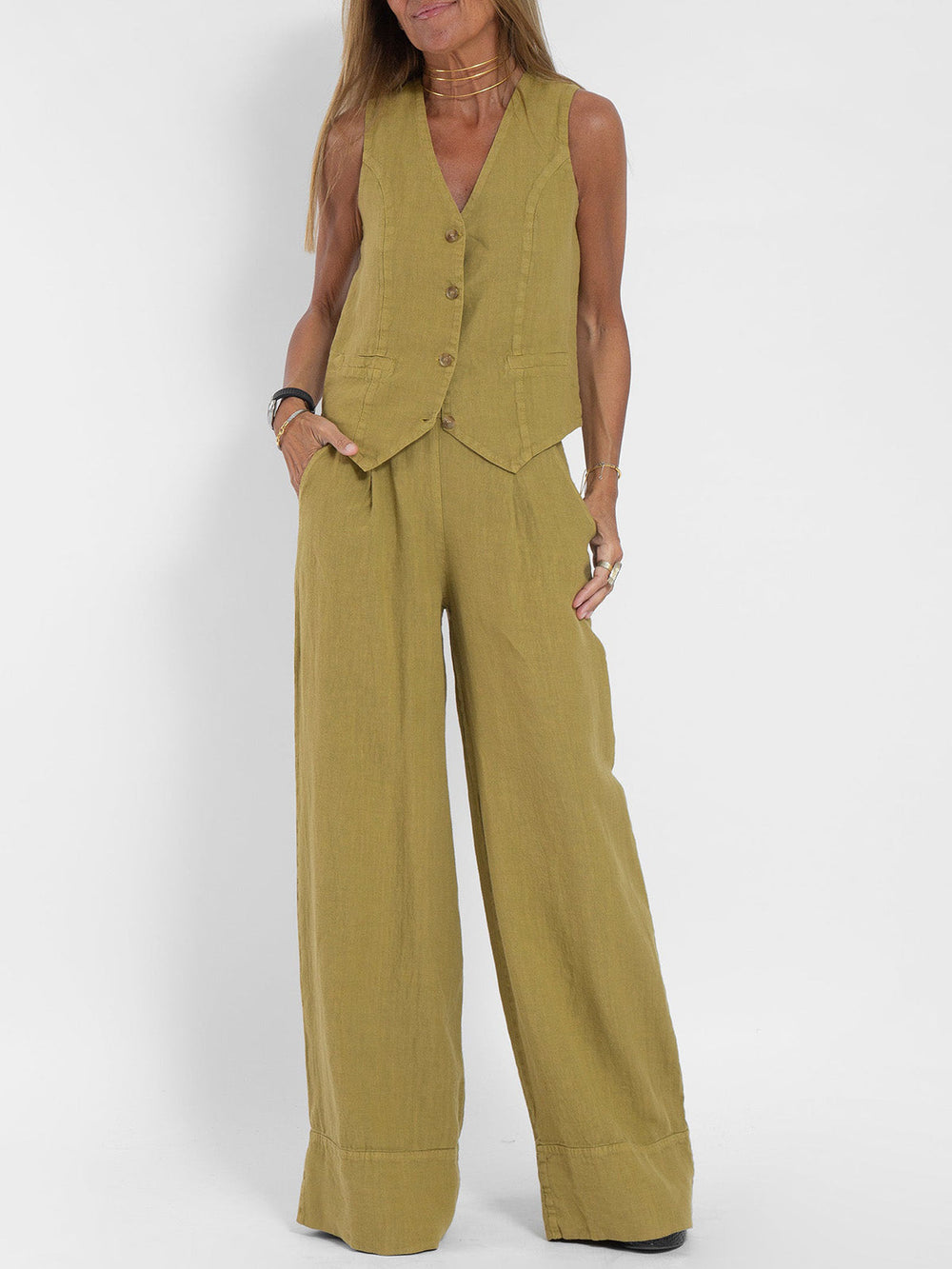 Woman wearing a Jhoana olive green linen vest and wide-leg pants set.