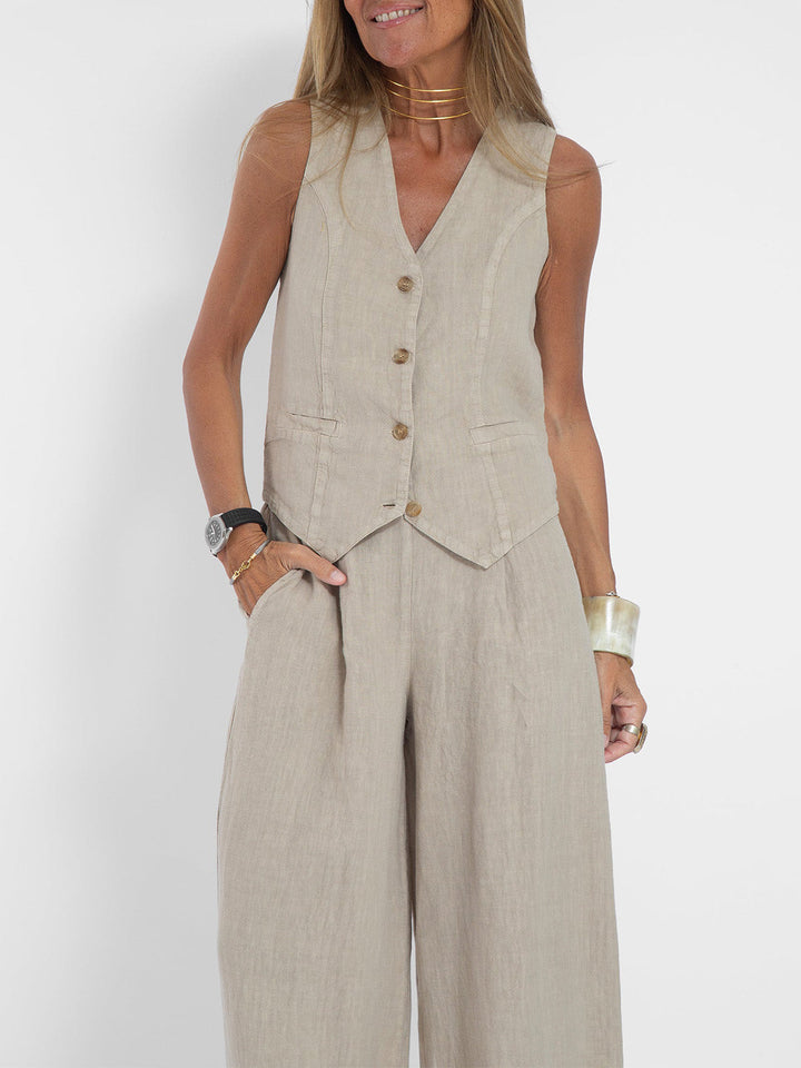 Woman in a beige linen vest and wide-leg pants set, featuring a V-neck and button-front vest.