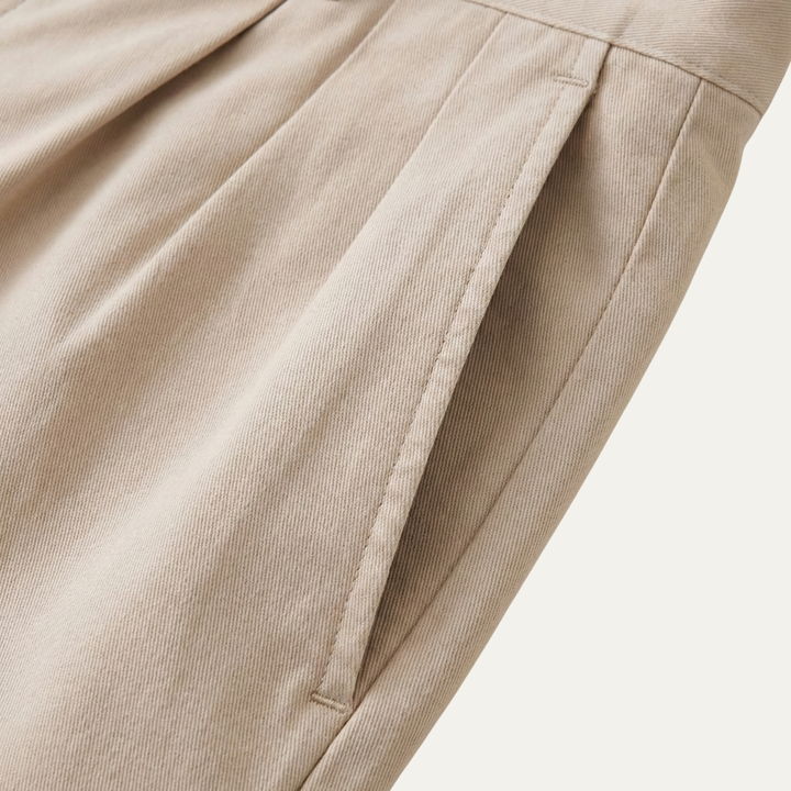 Close-up of Julian Men's Pleated Chino Shorts in a light beige color, showing a side pocket and pleats.