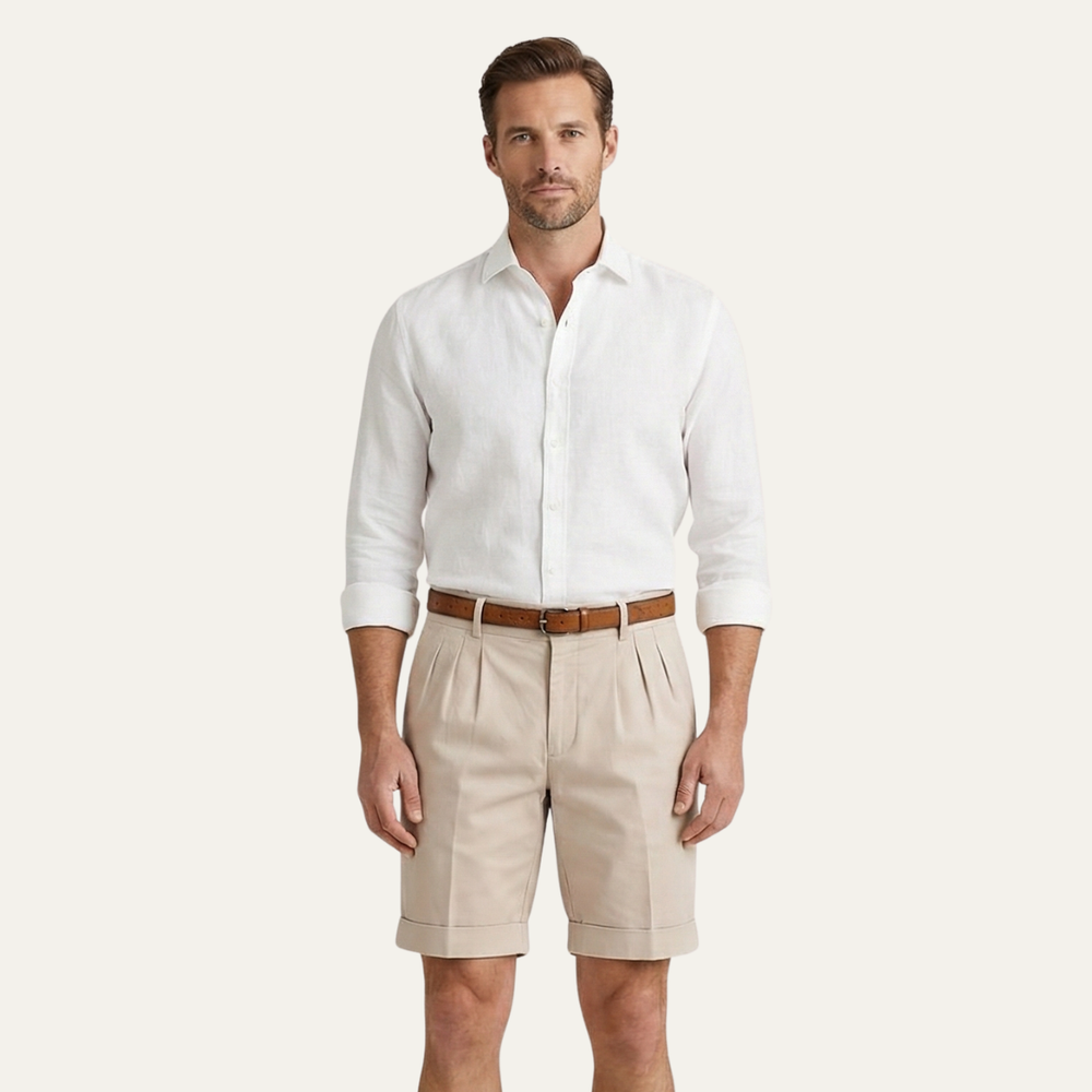 Men's Julian pleated chino shorts in light tan, with cuffed hems and a brown belt.