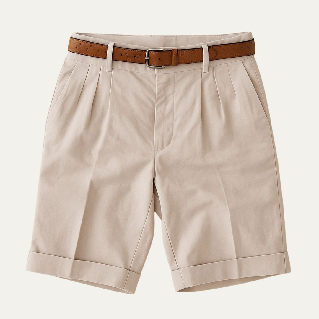 Julian Men's Pleated Chino Shorts in light beige with a brown leather belt, cuffed hems, and side pockets.