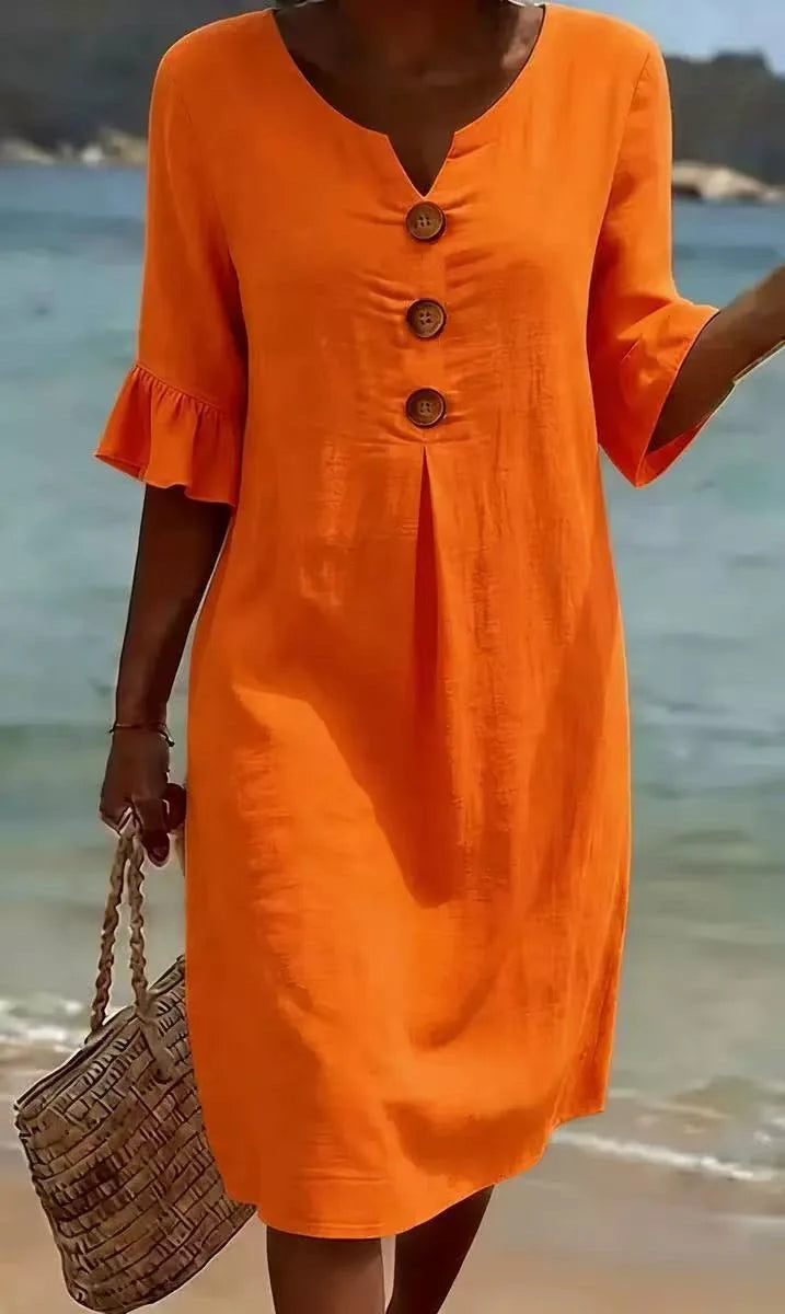 Orange linen V-neck midi dress with ruffle sleeves and decorative buttons on the beach.