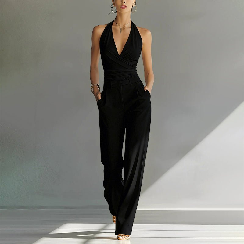 Elegant black halter wide-leg jumpsuit with a wrap-style bodice and side pockets.