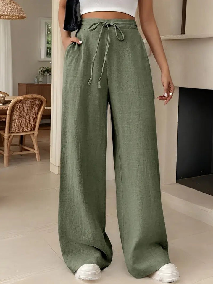 Women's olive green linen wide-leg pants with a drawstring waist and side pockets.