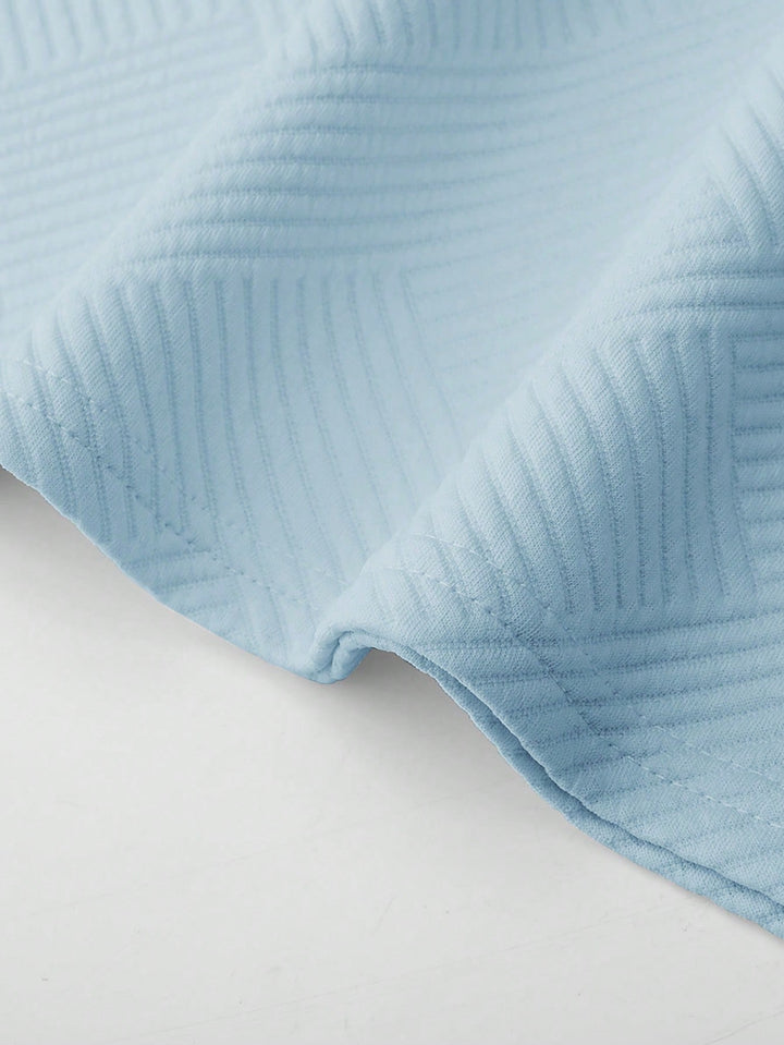 Close-up of light blue textured fabric from the Landon men's t-shirt and shorts set, showing subtle tonal pattern.