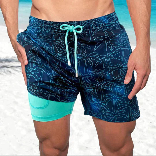 Men's Liam drawstring swim shorts in navy with a vibrant palm tree pattern and a visible mint green inner lining.