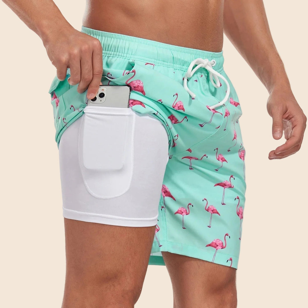 Men's Liam drawstring swim shorts in mint with pink flamingo pattern, inner lining, and phone pocket.