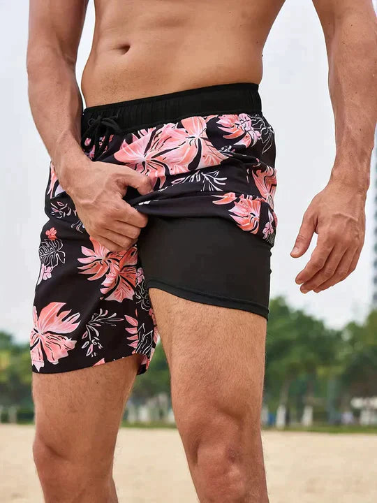 Men's Liam black drawstring swim shorts with vibrant pink floral pattern and built-in inner lining.