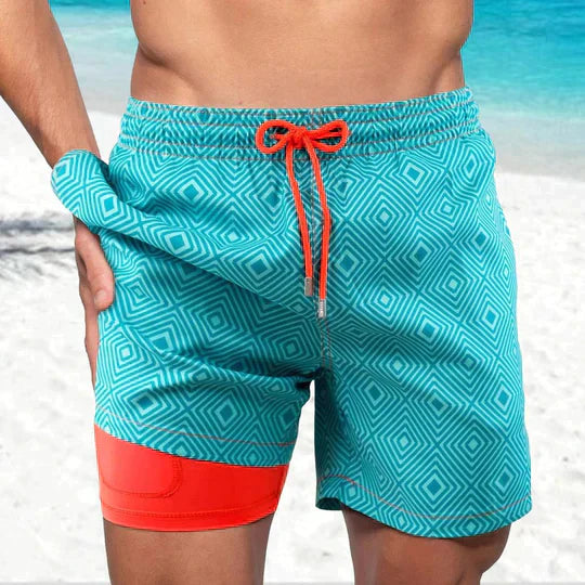 Men's Liam teal patterned swim shorts with a short, straight cut, orange drawstring, and inner lining.