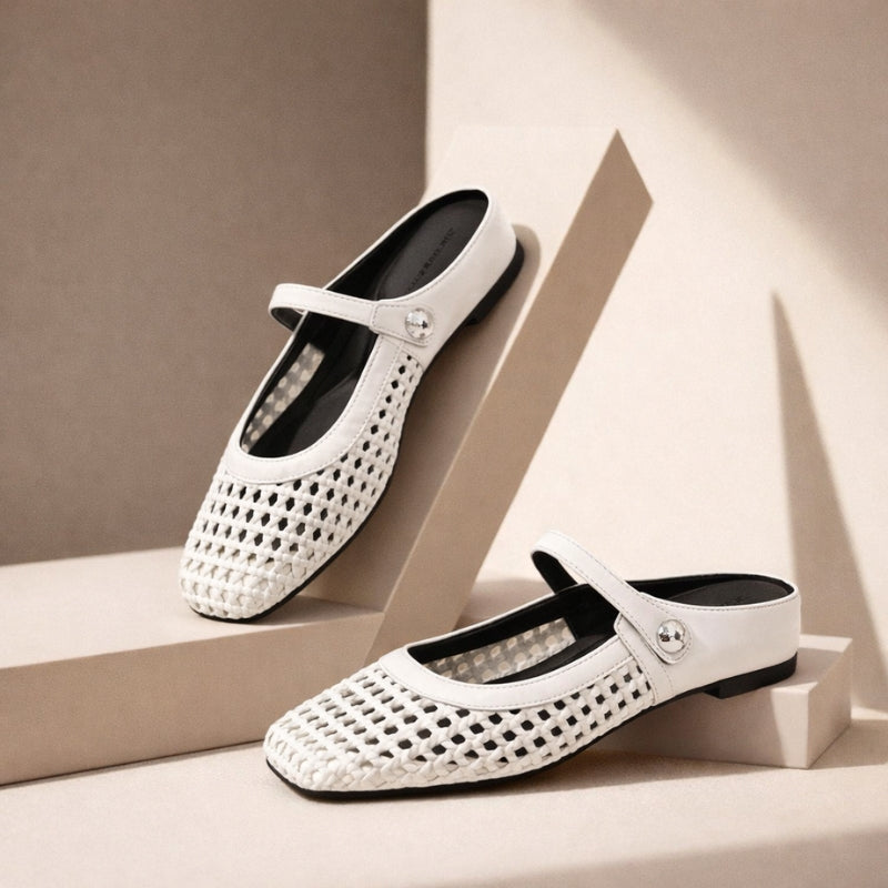 White woven leather Mary Jane flat mules with a silver button strap on beige geometric pedestals.