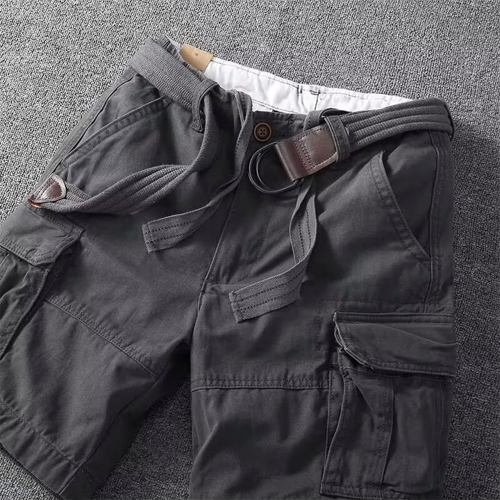 Men's Logan dark grey cargo shorts with visible pockets, button-front waist, and a brown leather-look belt.