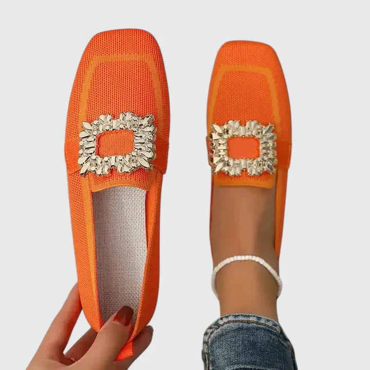 Orange Maylora women's orthopedic loafers with a prominent gold statement buckle, shown in size 5.