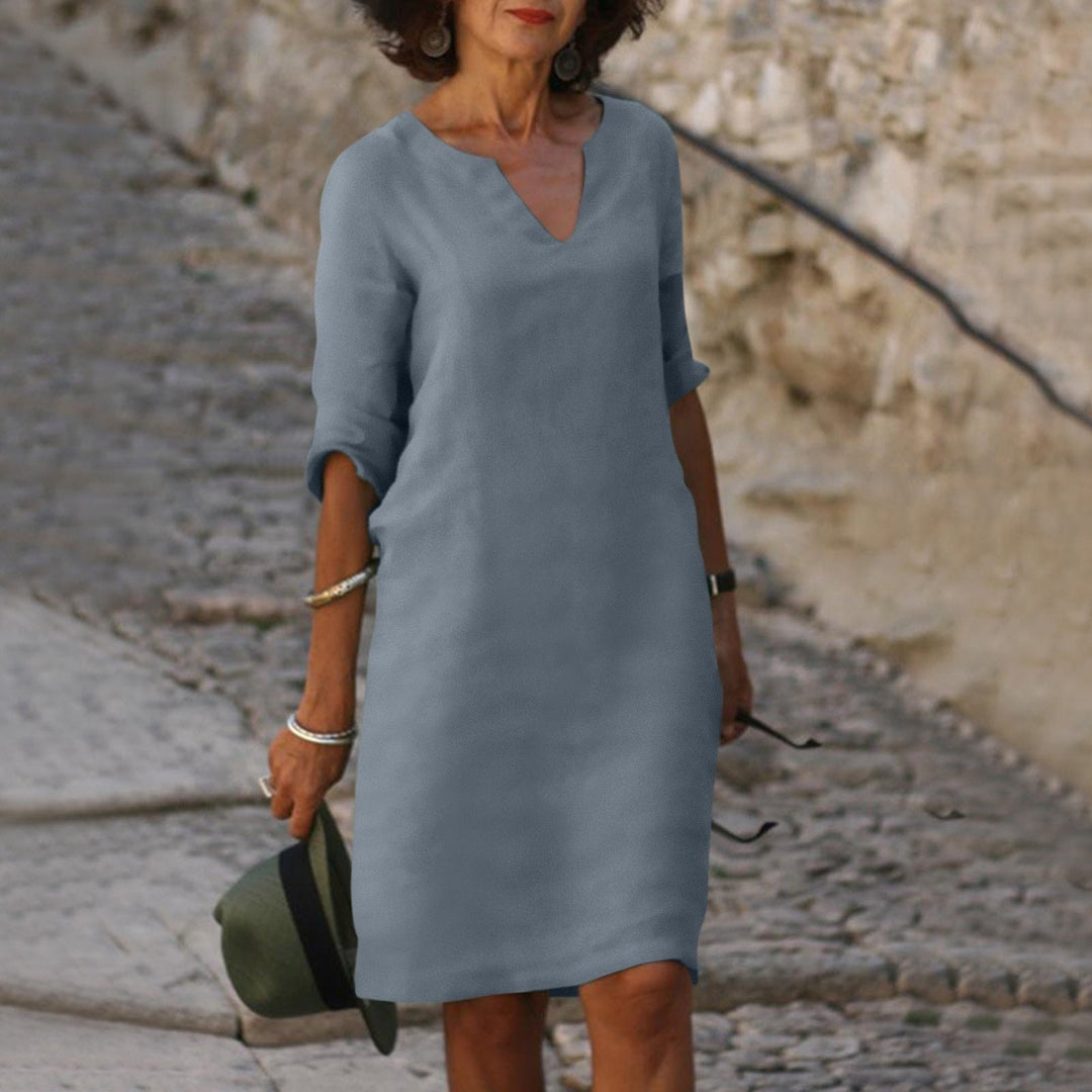 Woman in a flattering slate gray Mia summer dress with a V-neck, 3/4 sleeves, and lightweight fabric.