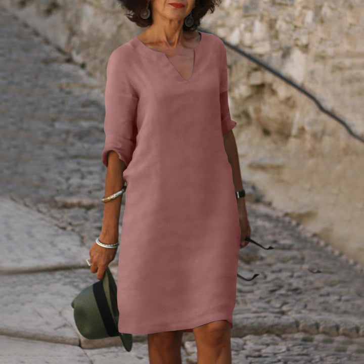 Woman in a flattering, lightweight Mia summer dress in a soft rose color with a V-neck and 3/4 sleeves.