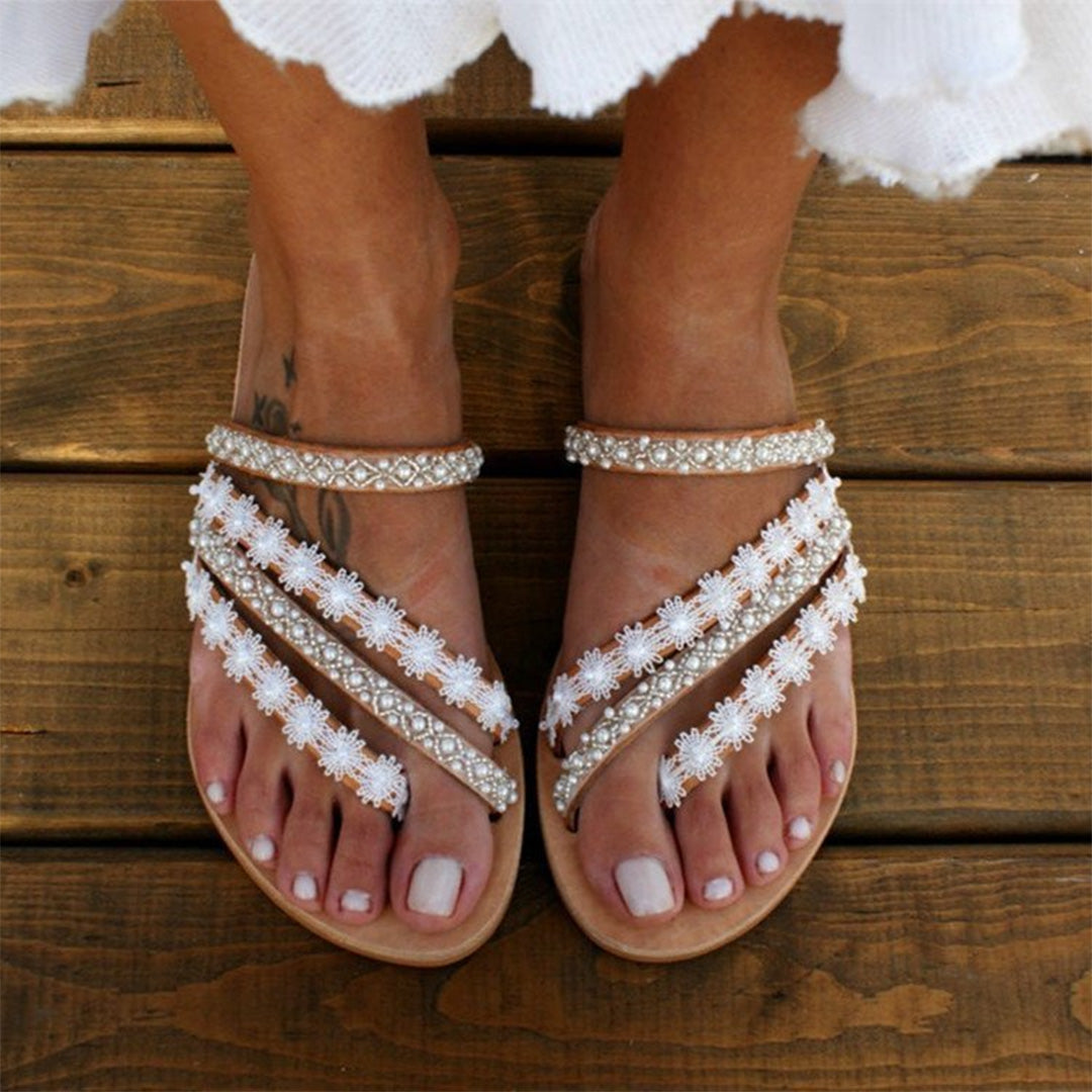 Women's Nellie boho flat sandals with white pearl lace straps and a light brown sole.
