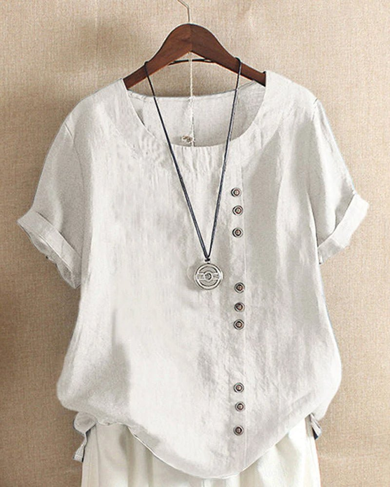 White linen tunic top with a relaxed fit, short rolled sleeves, and an asymmetrical button-front detail.