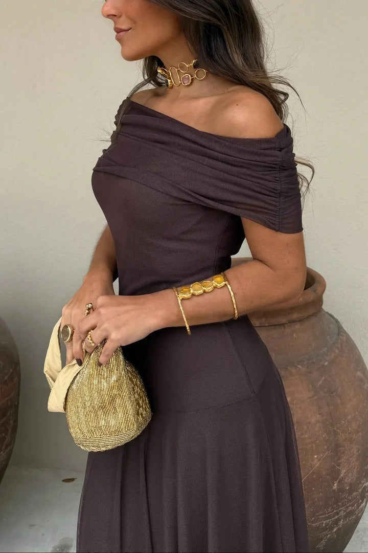 Nora women's one-shoulder pleated maxi dress in a rich color, with elegant gold jewelry and a beaded clutch.