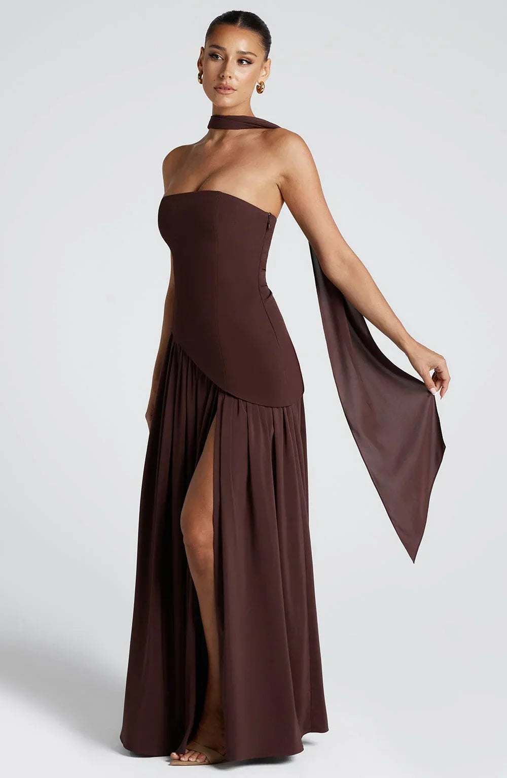 Black strapless corset maxi dress with a high slit, made from a sleek, form-fitting fabric.