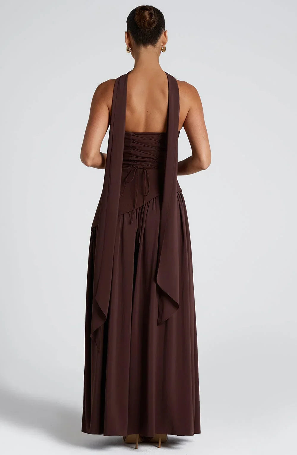 Black strapless corset maxi dress with a high slit, made from a sleek, form-fitting fabric.