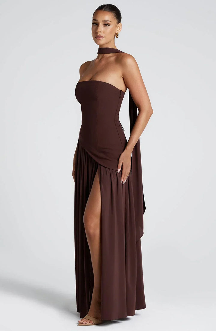 Black strapless corset maxi dress with a high slit, made from a sleek, form-fitting fabric.
