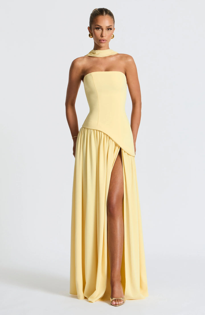 Lemon yellow strapless corset maxi dress with a high slit, made from a flowing fabric.