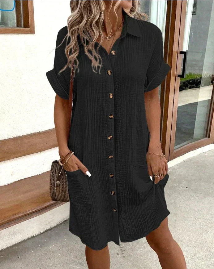 Black cotton button-up shirt dress with short sleeves and pockets.
