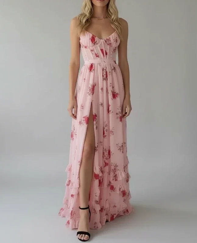 Pink floral spaghetti strap maxi dress with a high slit, made from flowing fabric.