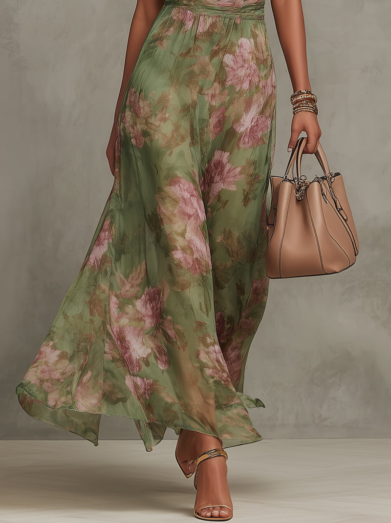 Sophia women's flowing green floral halter maxi dress with a defined waist, styled with a nude handbag and sandals.