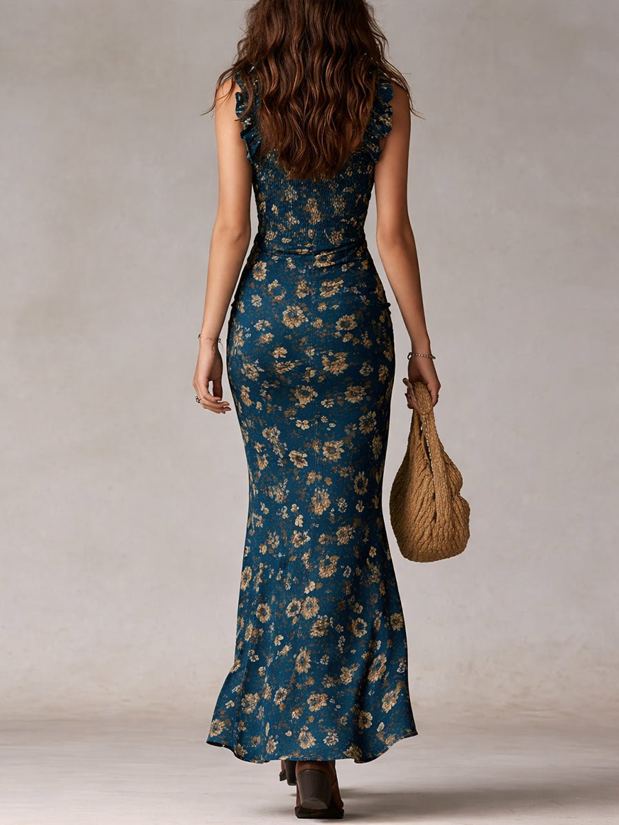 Woman from behind wearing a teal floral smocked ruffle maxi boho dress and carrying a woven bag.