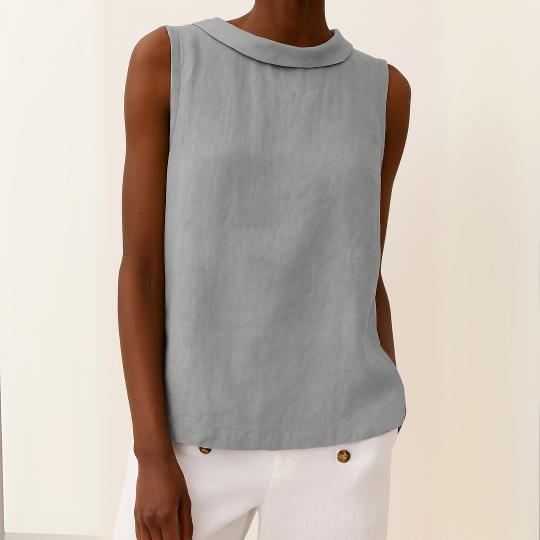 Model wearing a light grey sleeveless top with a modern roll collar and a soft, draped linen-blend fabric.