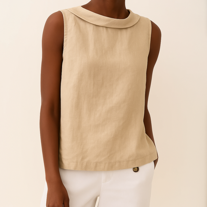 Beige sleeveless top with a modern roll collar and soft, draped fit, paired with white trousers.