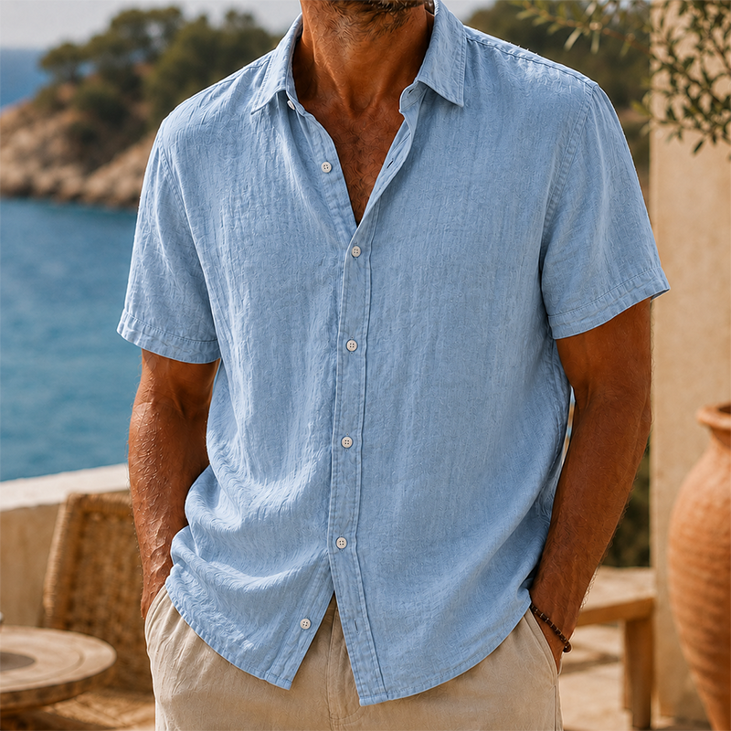 Men's light blue linen short-sleeve button shirt with a collared neckline and textured fabric.