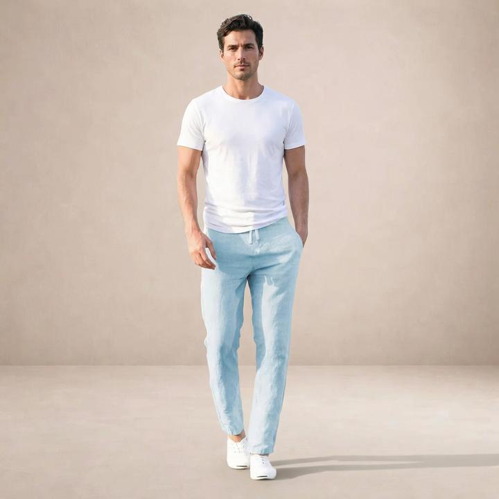 Man wearing light blue Wesley linen summer pants with a white t-shirt and sneakers.