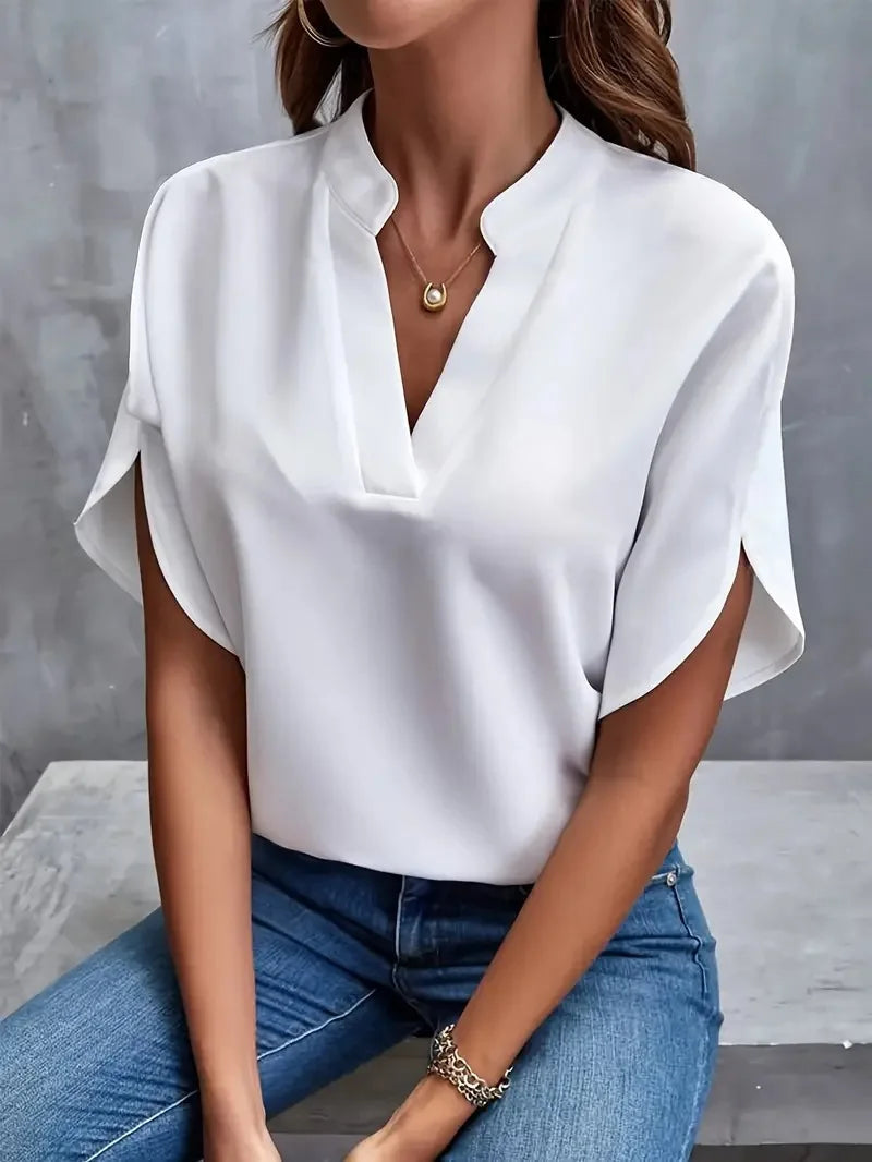 Willa women's white V-neck blouse with flowy sleeves, paired with jeans.