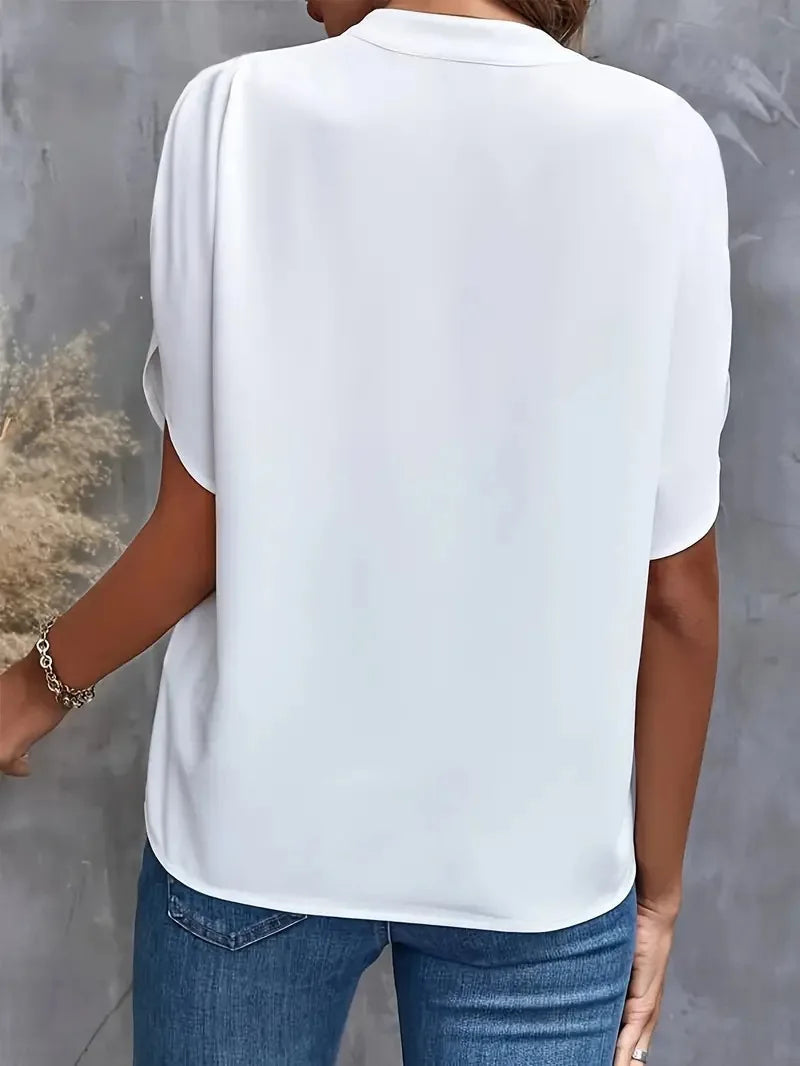 Willa women's white V-neck blouse, soft and flowy, paired with jeans.