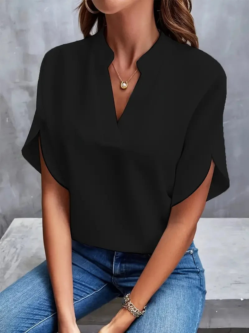 Willa women's black V-neck blouse with flowy short sleeves, paired with jeans.